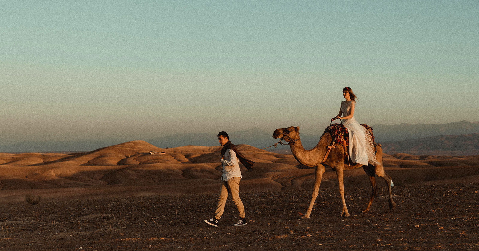 Wedding couple in the desert with a camel filmed by a Morocco Wedding Videographer