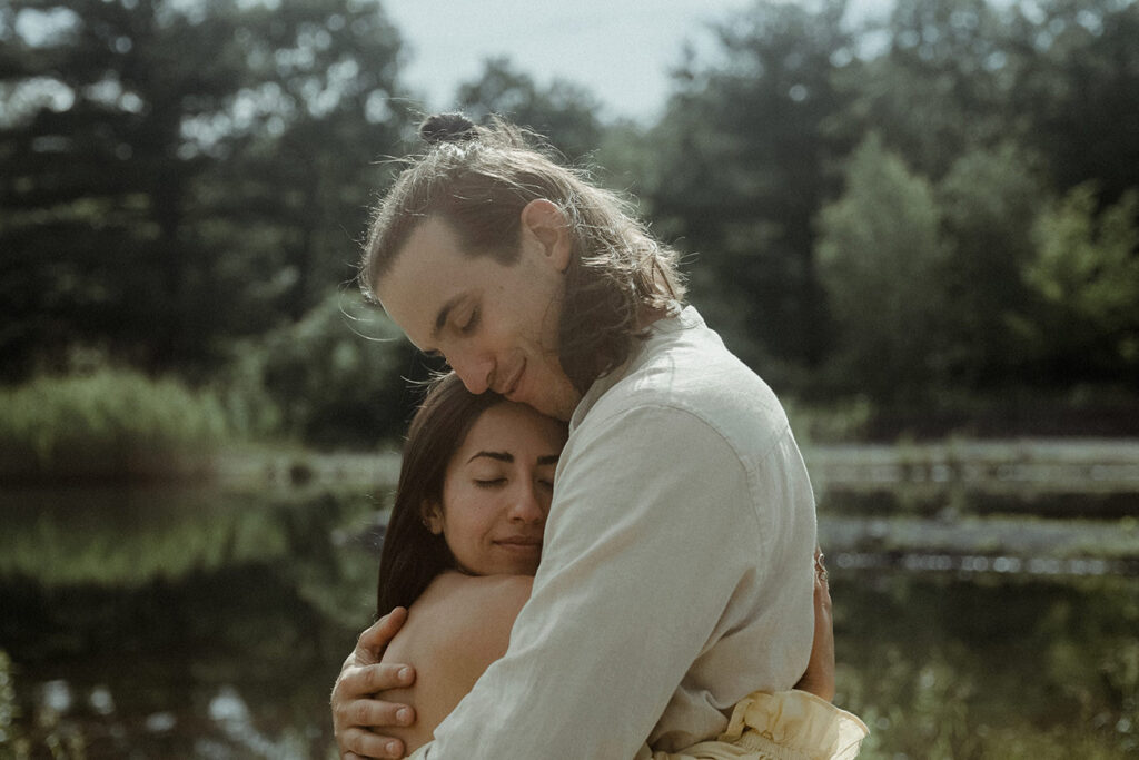 couple hugging in front of a pond