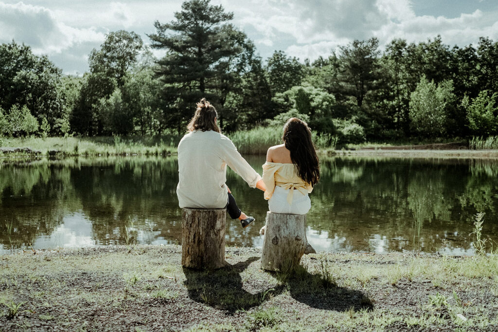 Couple holding hands in front of a pond in Gather Greene Upstate New York