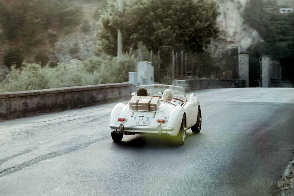 wedding couple driving vintage car in the Amalfi Coast