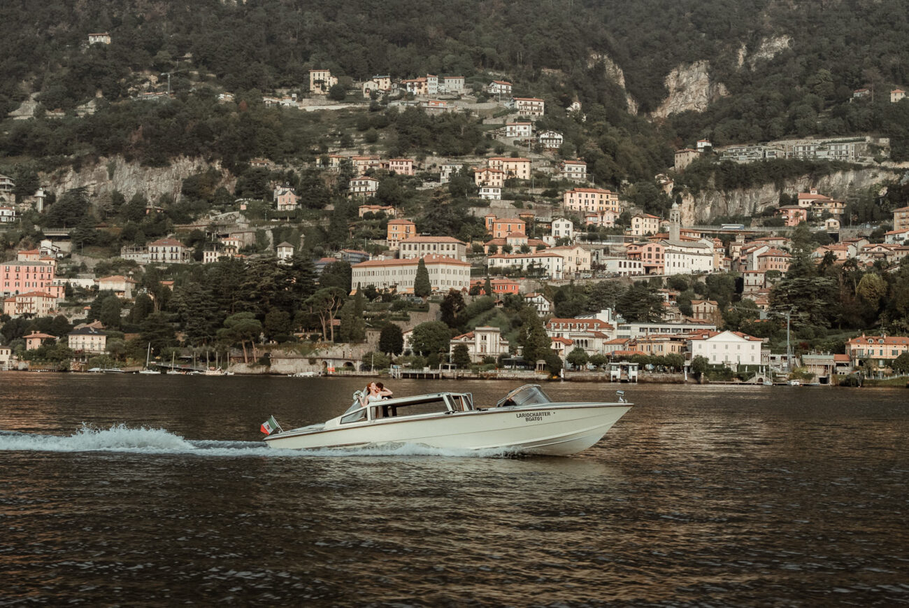 A couple cruising on a boat in Lake Como, one of the Best Adventure Elopement Locations in Italy