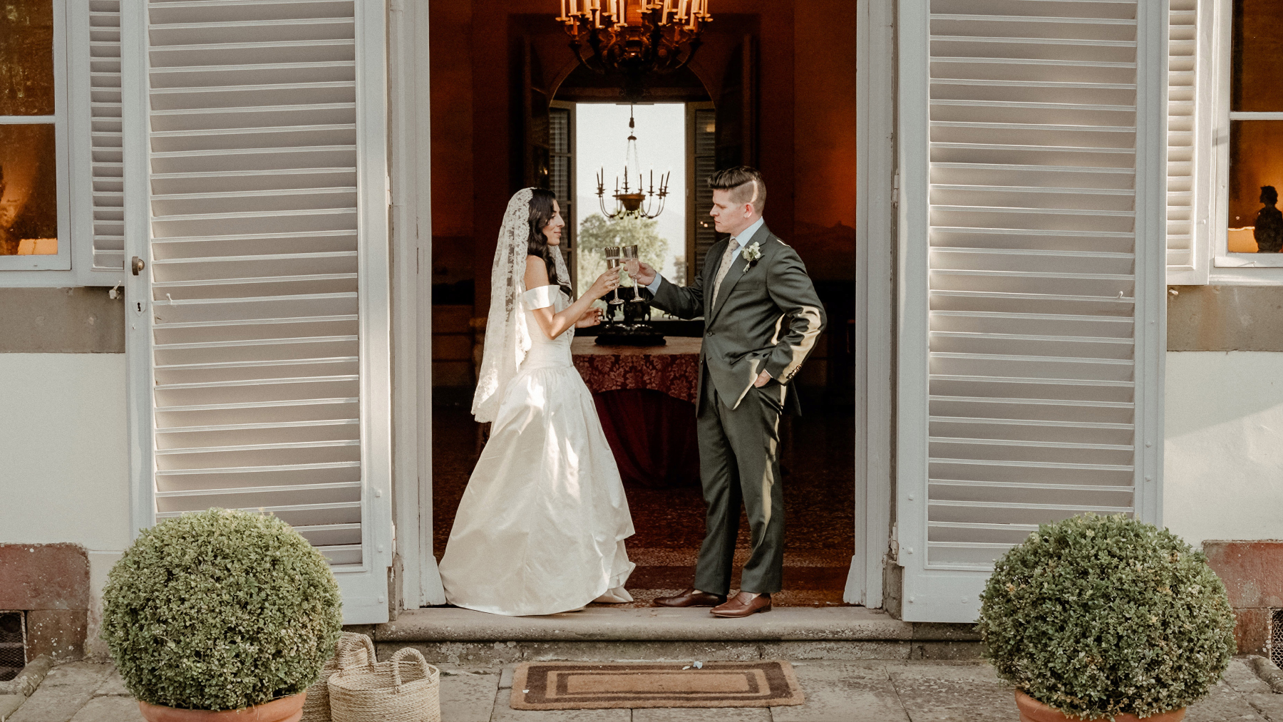 Couple holding champagne from a Persian Sofreh Aghd Wedding at Villa Grabau, Tuscany