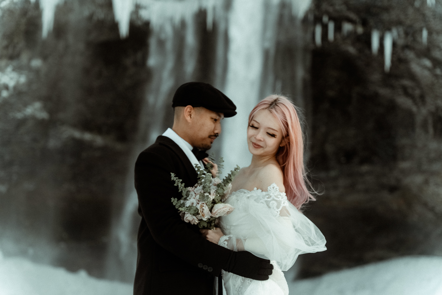Couple in Iceland in front of a waterfall filmed by an Elopement Videographer for Intentional and Intimate Celebrations