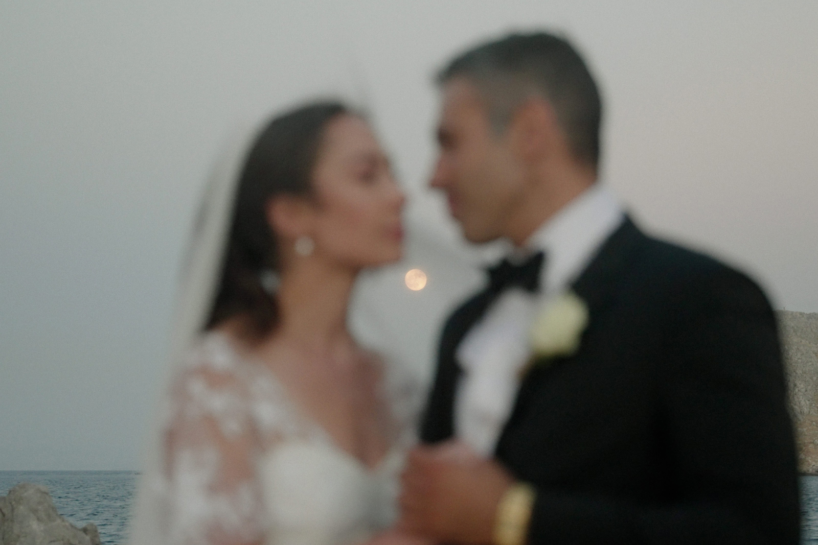Greek Island wedding in Chios - couple married at Agios Isidoros Chapel looking at each other and the full moon between their faces