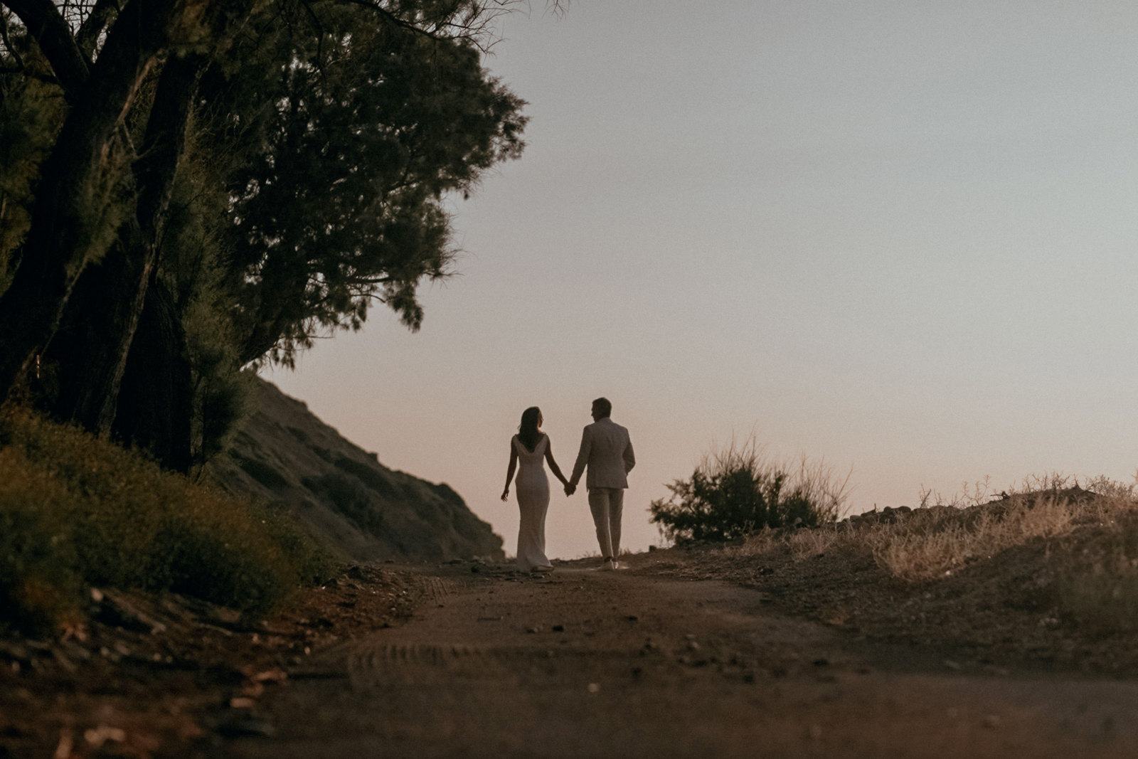 Couple holding hands on the beach at dusk for a Greek Island wedding in Chios