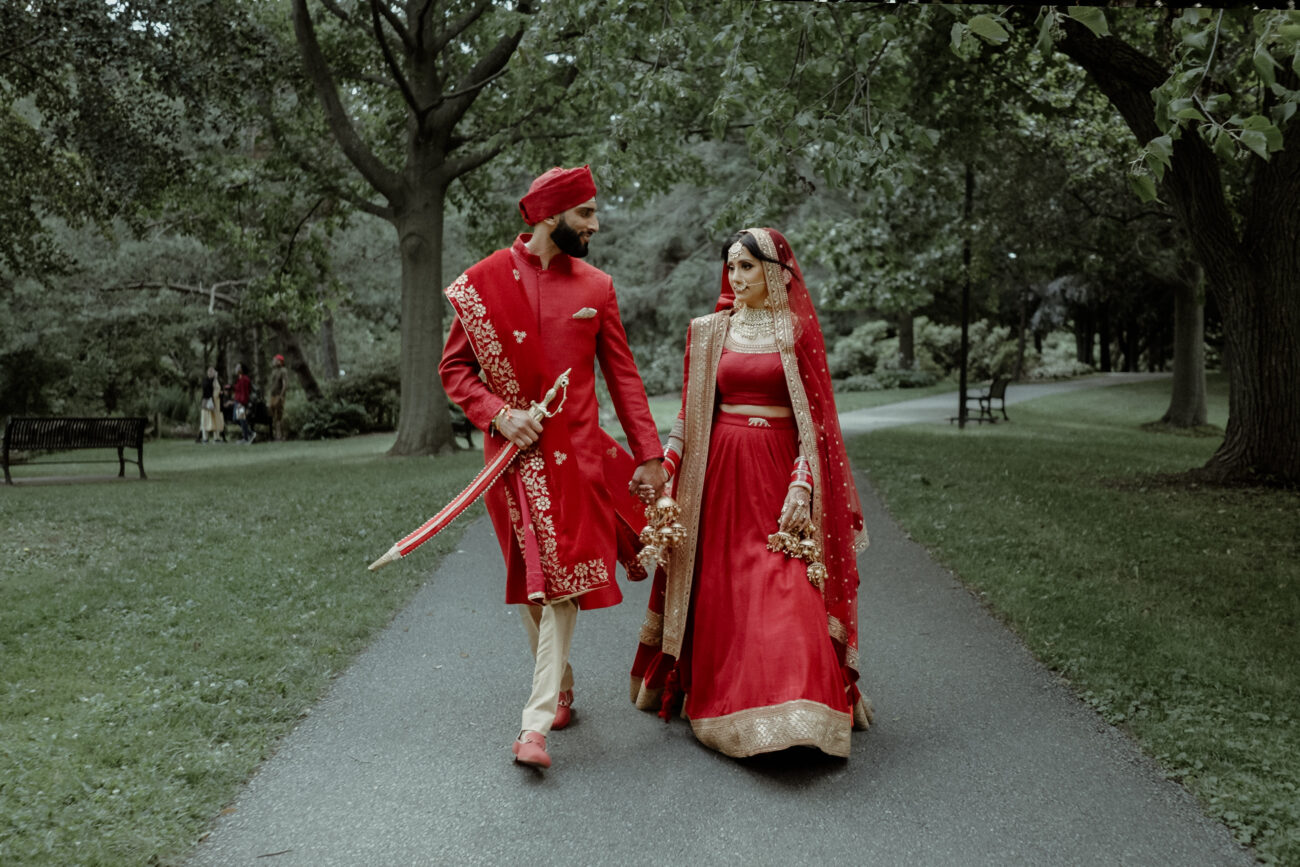 Toronto Wedding Videographer 8 Toronto Wedding Videographer filming Sikh couple in traditional attire walking hand in hand in Mississauga