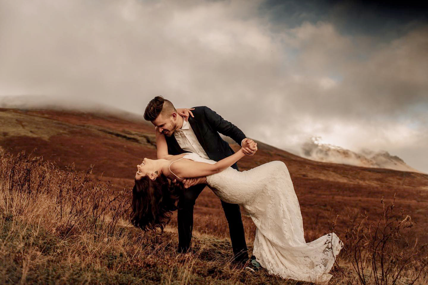 Iceland Elopement Videographer for Adventure & Intentional Celebrations 10 A couple in wedding attire dancing on a hill, filmed by an Iceland Elopement Videographer
