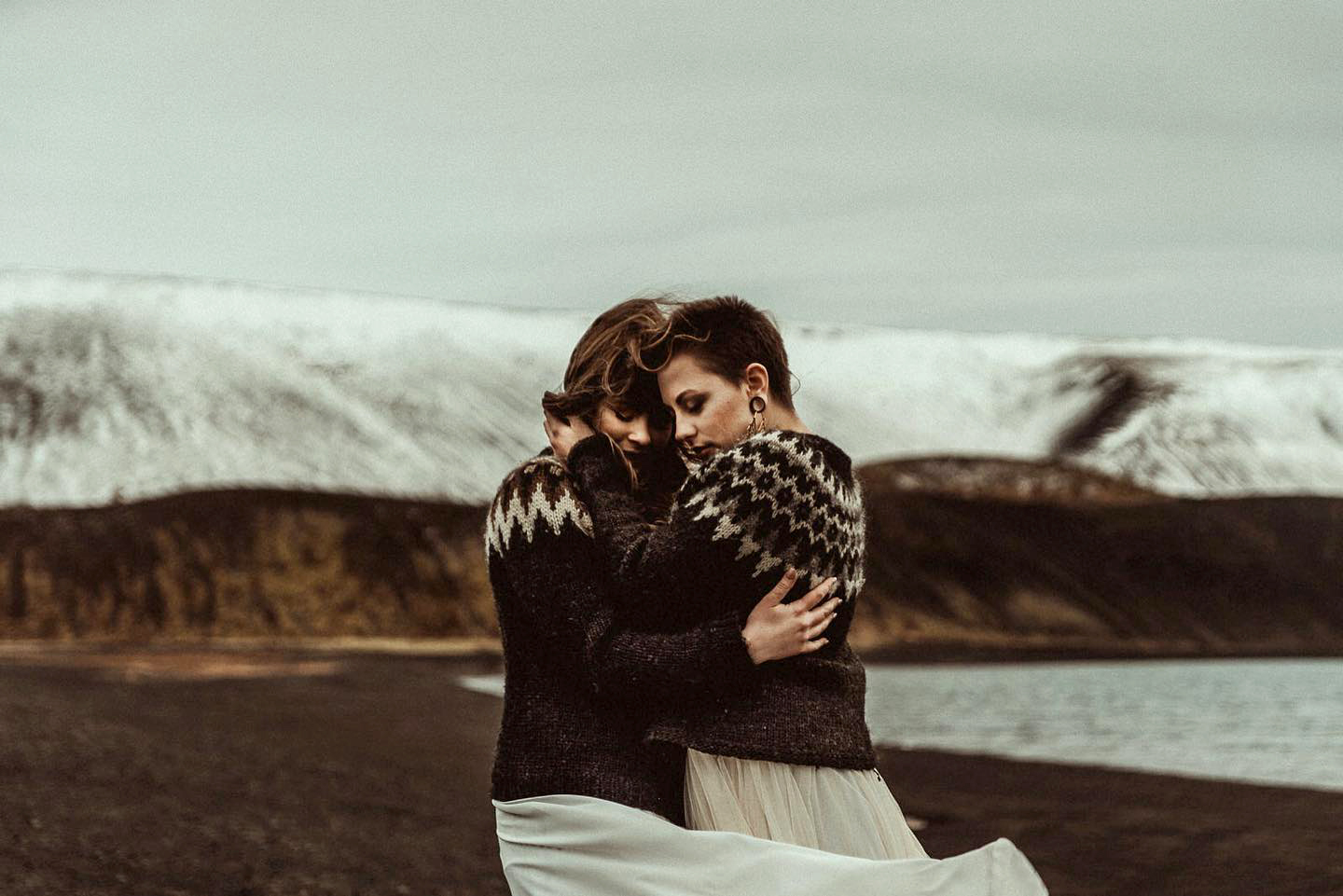 Iceland Elopement Videographer for Adventure & Intentional Celebrations 8 Two brides hugging on a shore of a lake, filmed by an Iceland Elopement Videographer