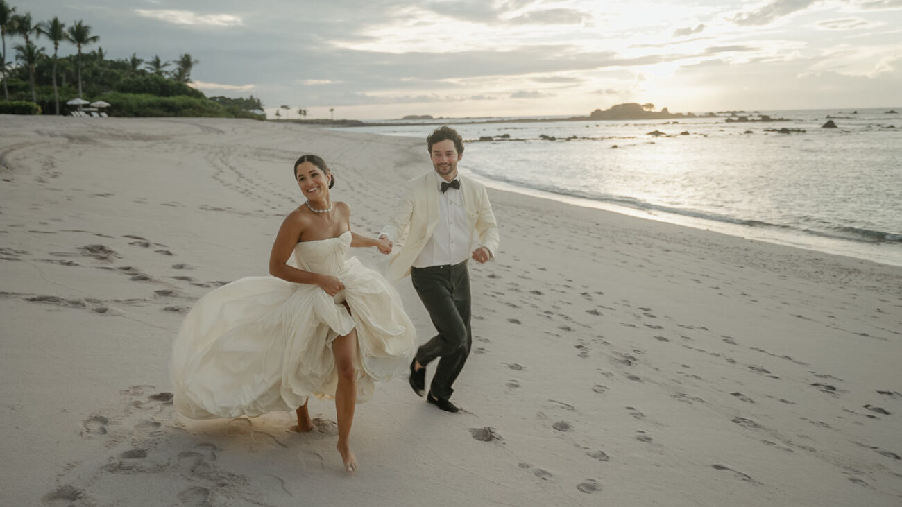 Couple running on the beach in Punta Mita filmed by a Mexico Wedding Videographer for Destination Weddings