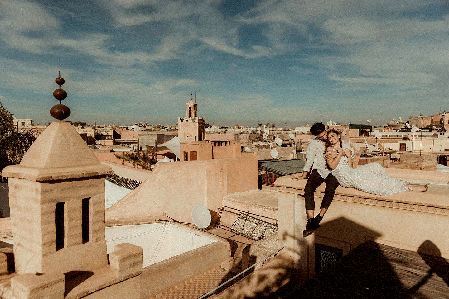 Couple in wedding attire sitting on a rooftop in Marrakech filmed by a morocco wedding videographer