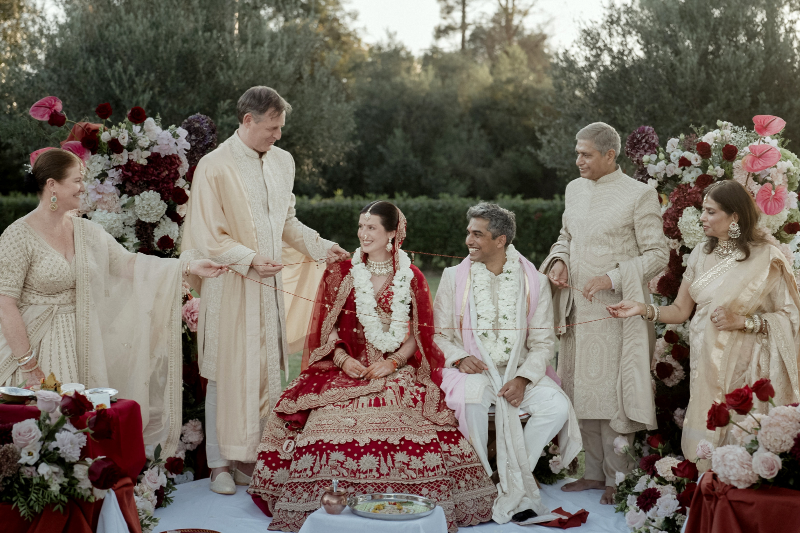The parents hold a sacred thread around the couple during a Hindu wedding ceremony in Corfu, filmed by a Wedding Videographer in Greece