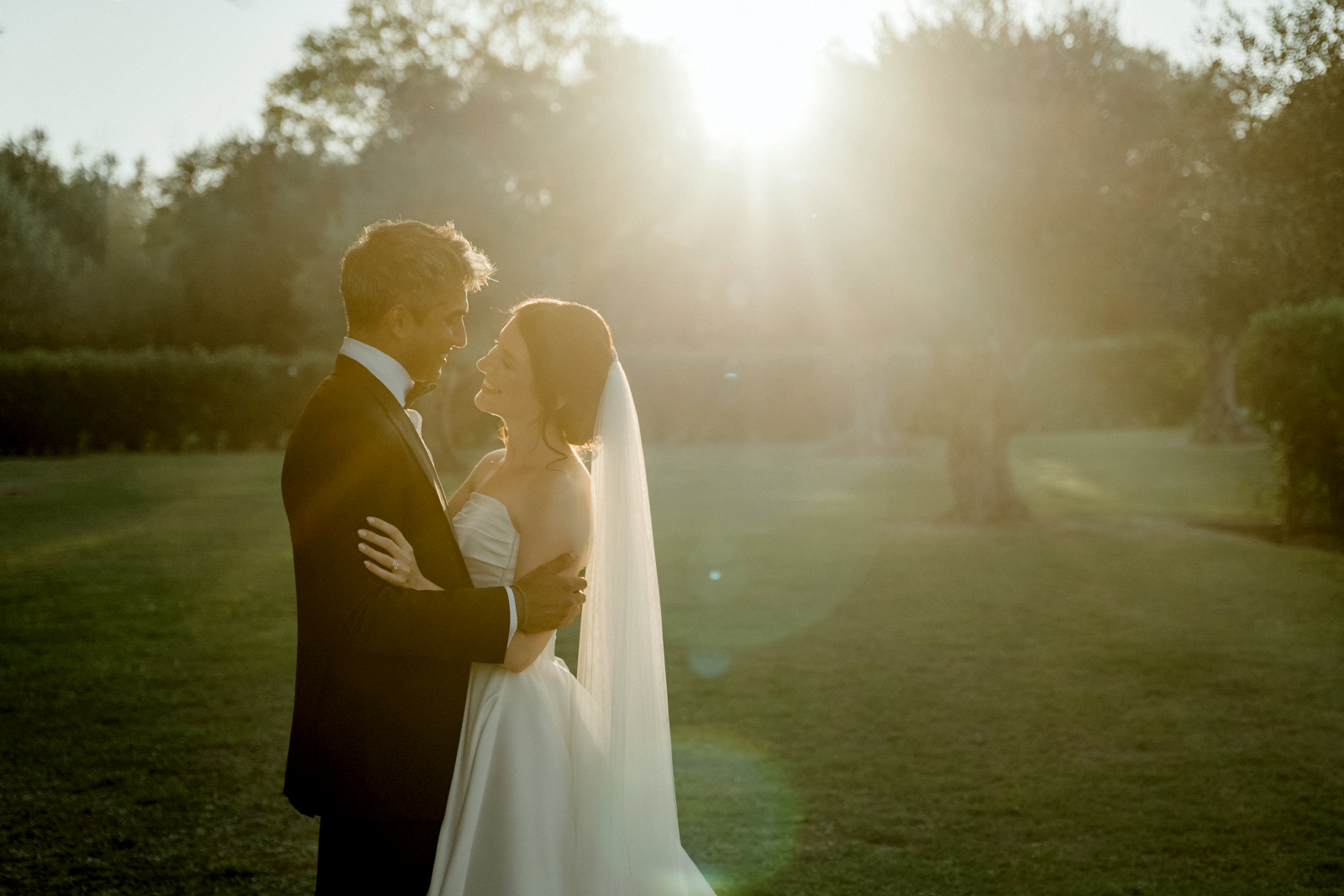 Indian Destination Wedding in Corfu at Natura Estate 9 A couple in wedding attire bathed by sunlight amidst the olive groves after their Indian Destination Wedding in Corfu at Natura Estate