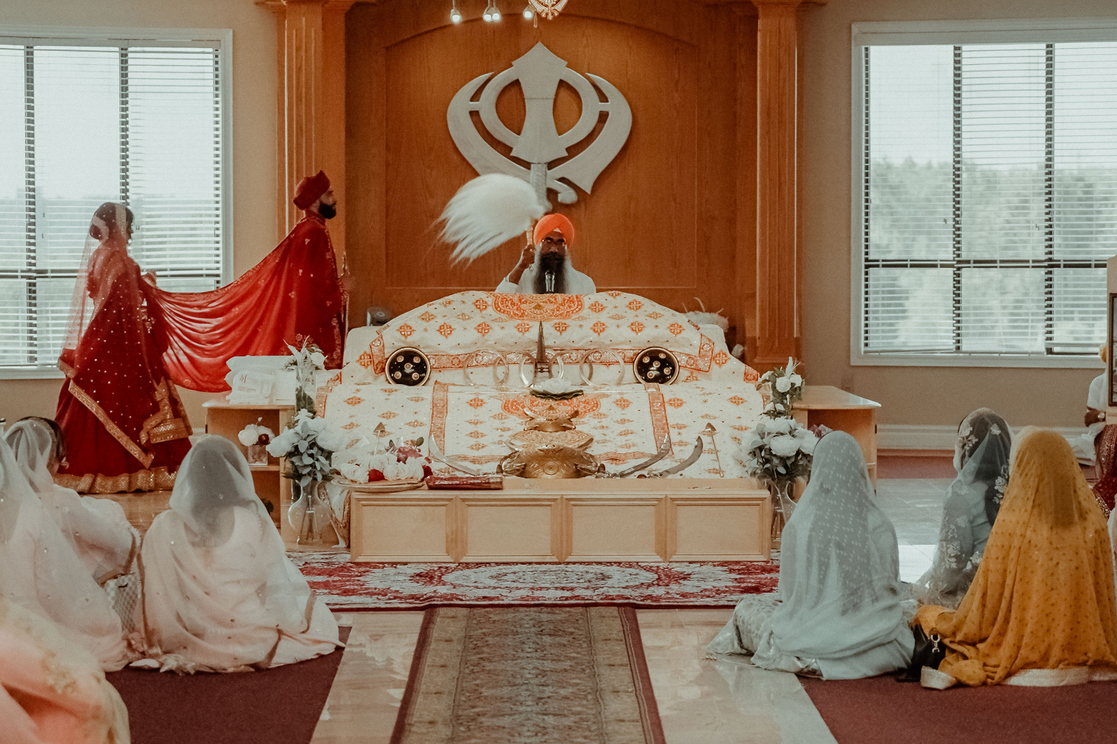 Sikh Wedding in Toronto - A Story of Faith and Reflection 4 A couple in Indian wedding attire walking around the guru in the Gurdwara during their Sikh Wedding in Toronto