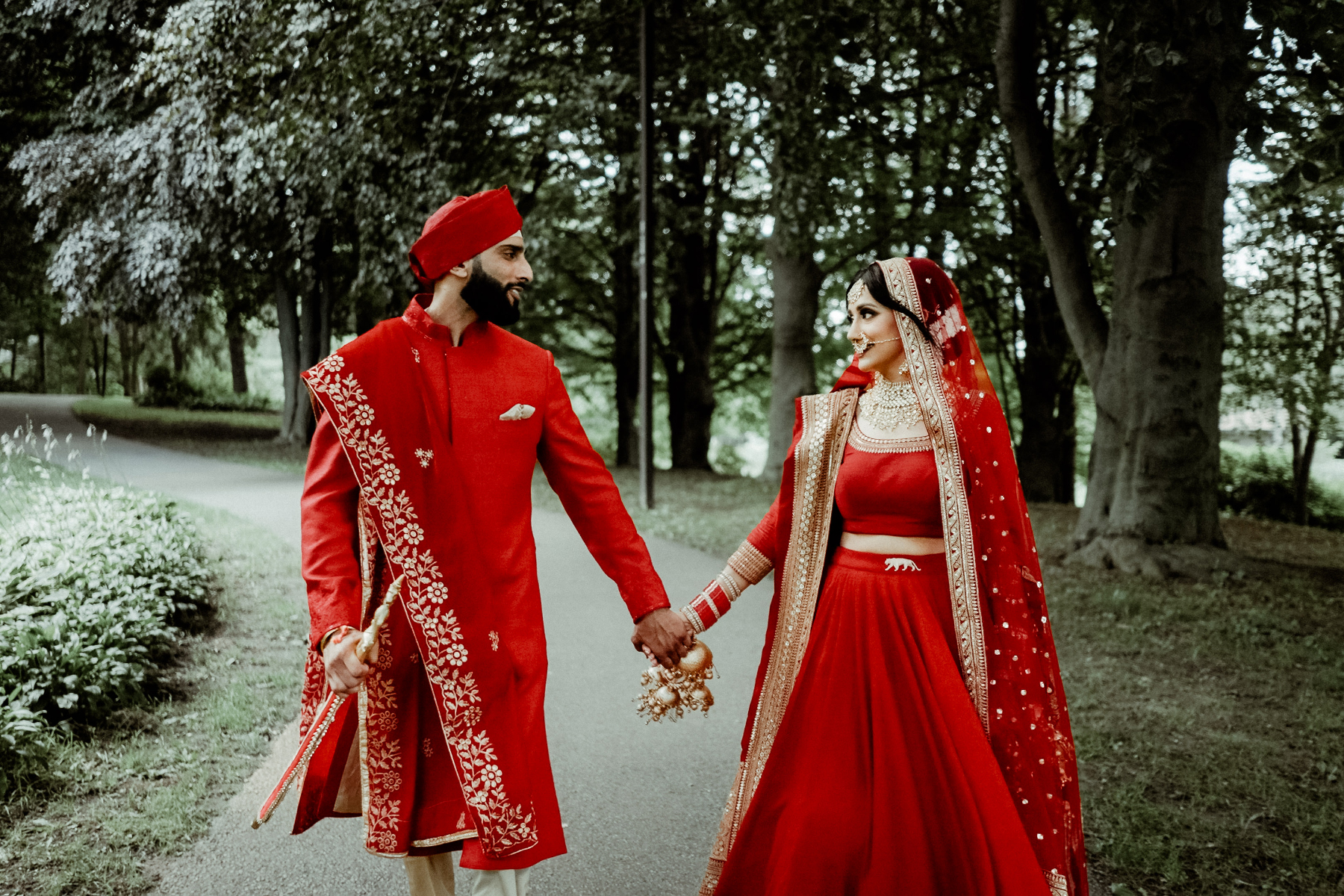 Sikh Wedding in Toronto - A Story of Faith and Reflection 10 A couple in Indian wedding attire holding hands outdoors after their Sikh Wedding in Toronto