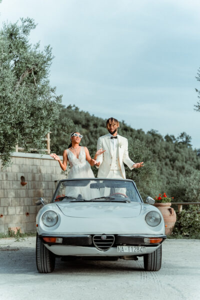 Black couple dancing inside a vintage Alfa Romeo Spider cabrio filmed by their Wedding Videographer in Amalfi Coast