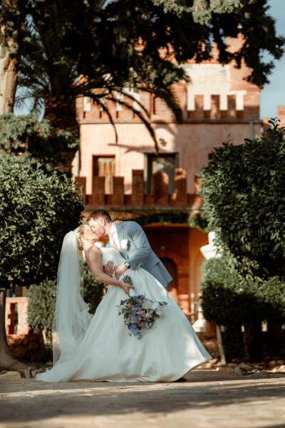 A couple kissing in front of Melissourgos Castle in Athens, filmed by their Greece Wedding Videographer