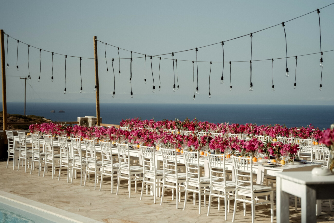 How to Plan a Destination Wedding in Greece, What to Know Before You Begin 11 Dinner table setup for a destination wedding in Greece, Paros, decoration made of bugainville flowers and lemons