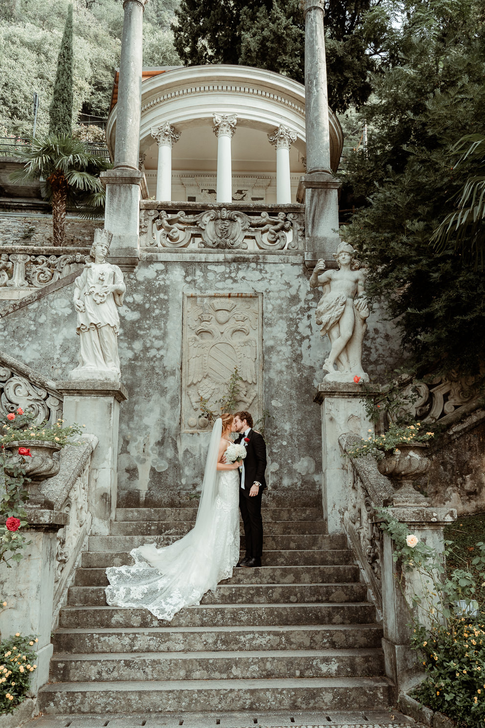 Italy Wedding Videographer for Destination Weddings 9 A wedding couple kissing on the steps of Villa Monastero in lake Como, filmed by their Italy Wedding Videographer