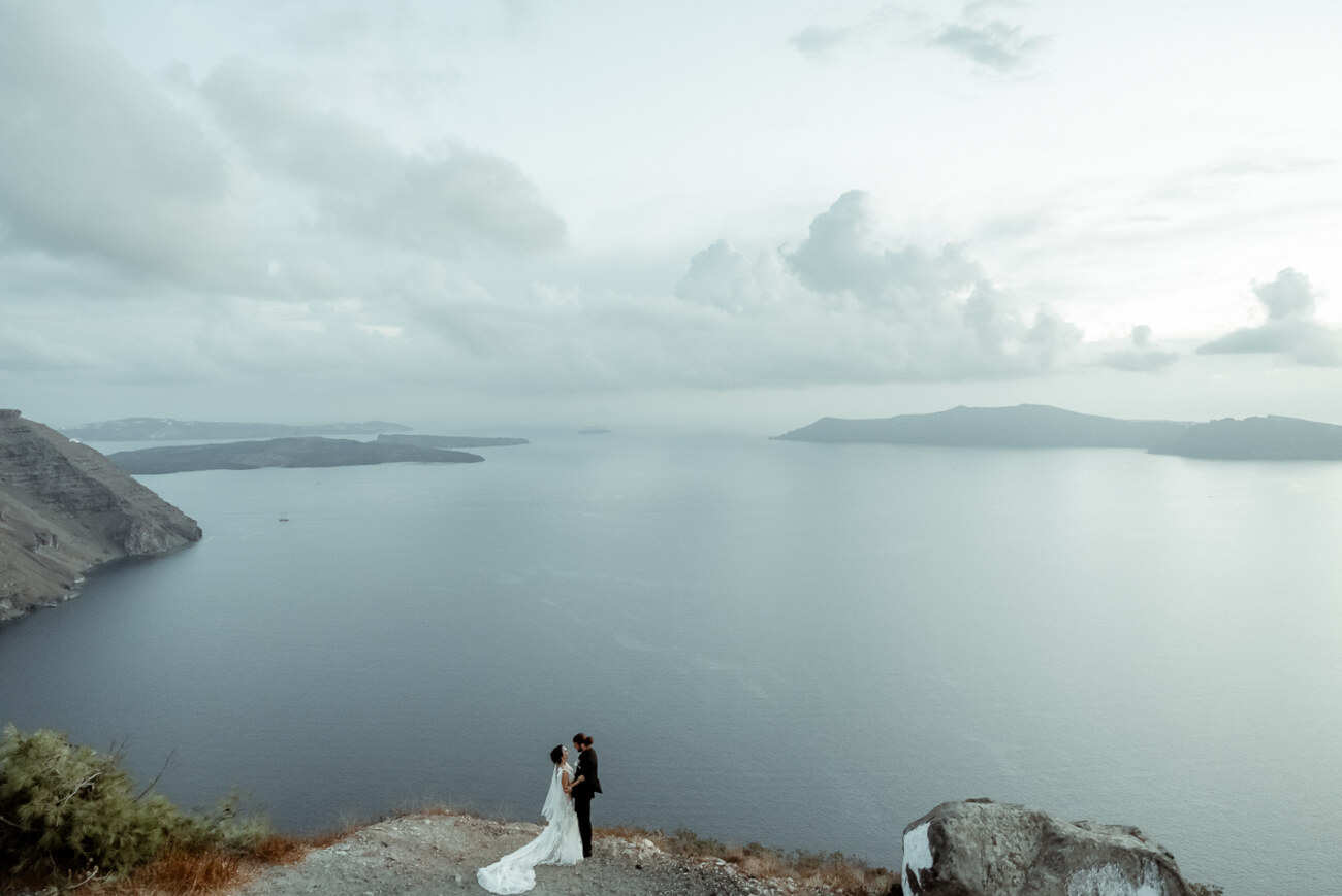 How to Plan a Destination Wedding in Greece, What to Know Before You Begin 8 A wedding couple in Imerovigli Santorini with an overcast weather