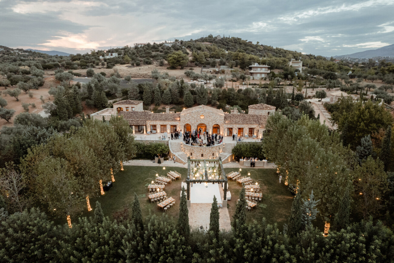 How to Plan a Destination Wedding in Greece, What to Know Before You Begin 10 Aerial view of Pyrgos Petreza during a wedding reception with the tables placed in a semi circle setup