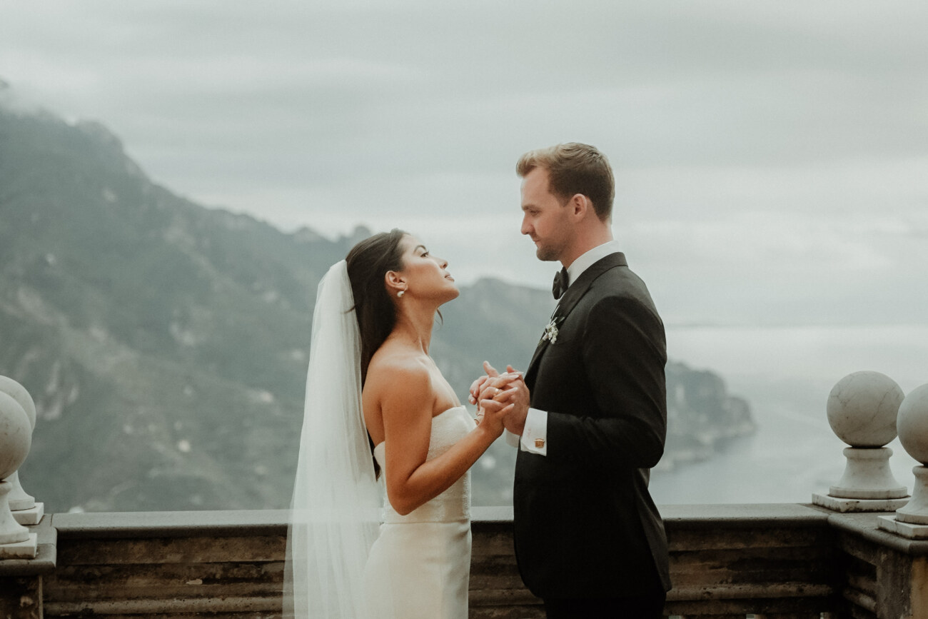 A wedding couple holding hands in Palazzo Avino Ravello on a cloudy afternoon
