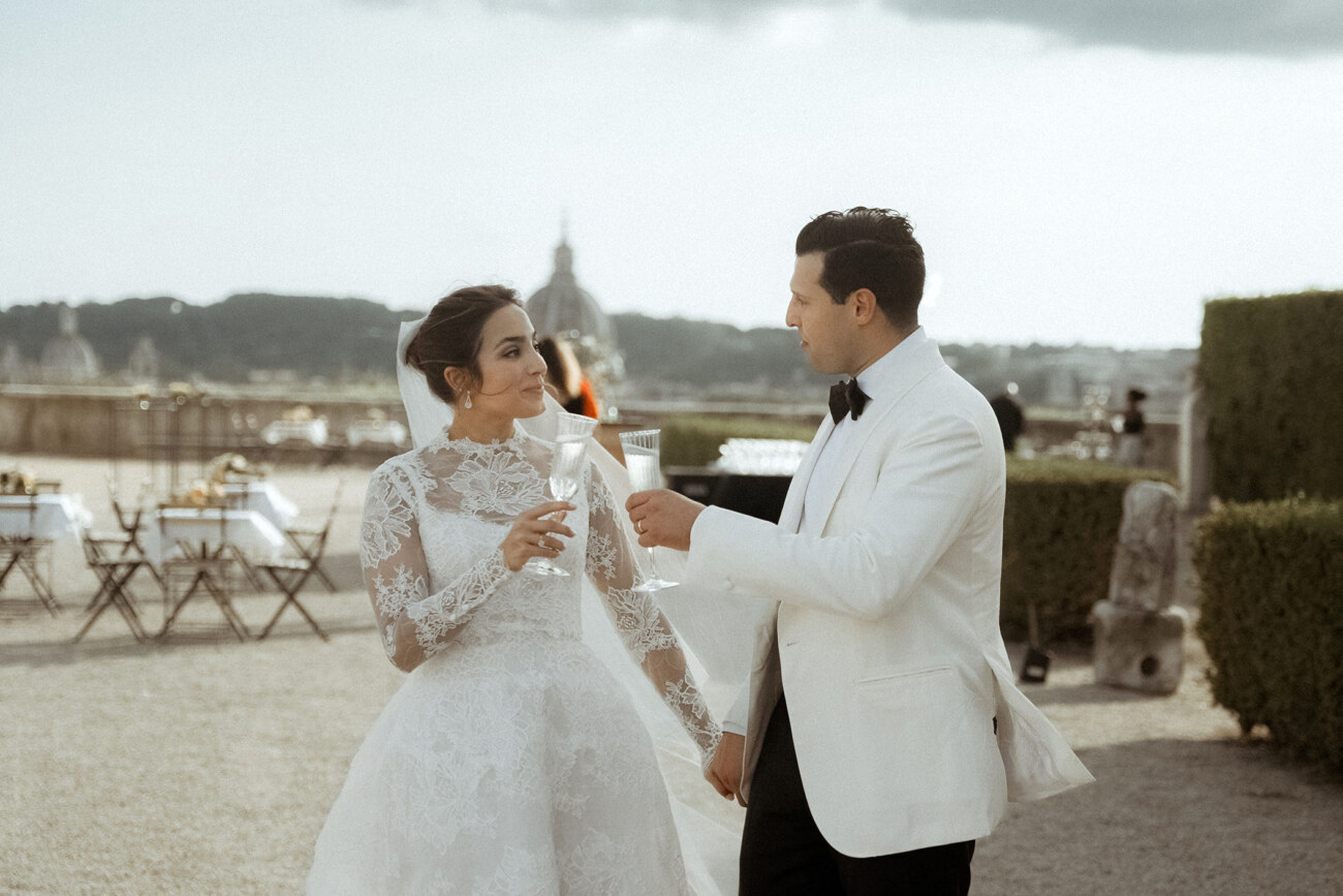 A wedding couple cheering with glasses of champagne after their destination wedding in Italy 