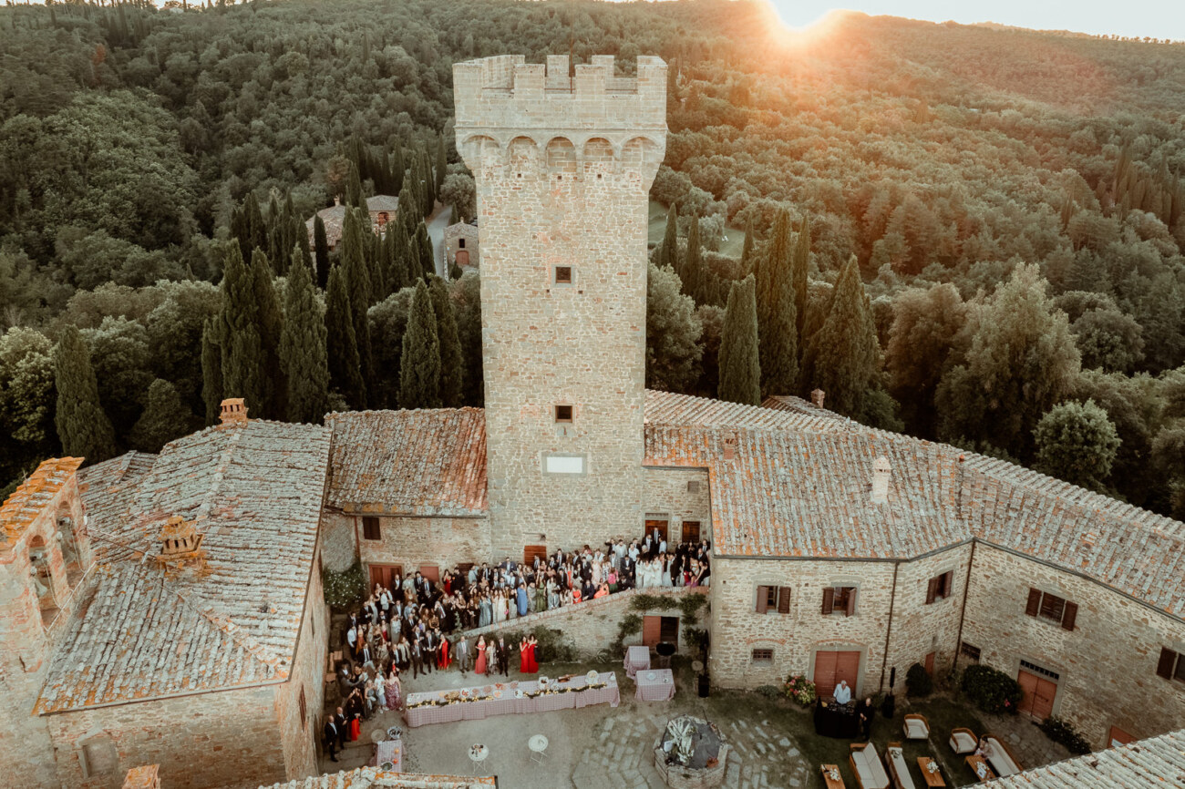 Aerial group picture of guests at a destination wedding in Italy at Castello di Gargonza at sunset
