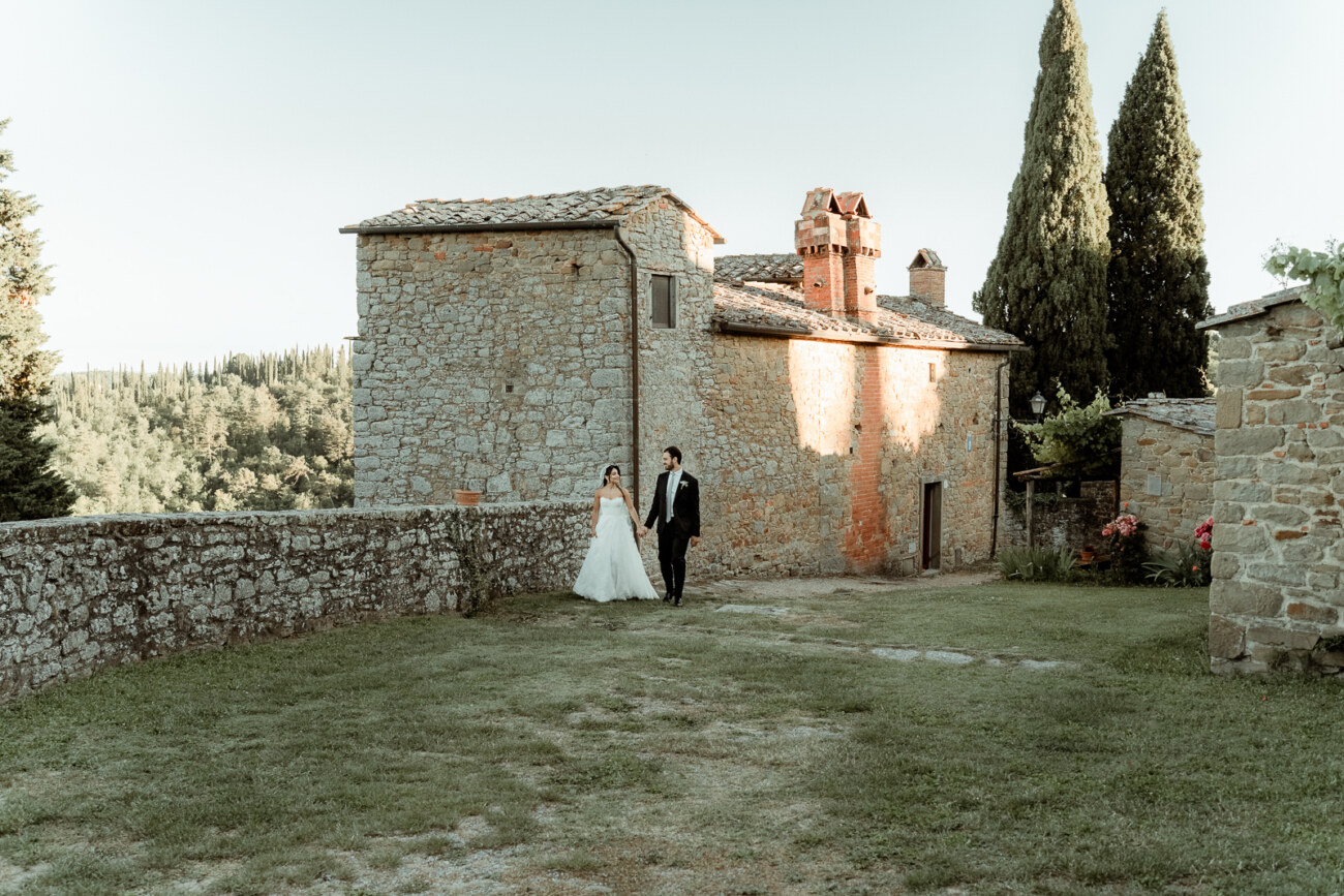 A wedding couple walking hand in hand in Tuscany
