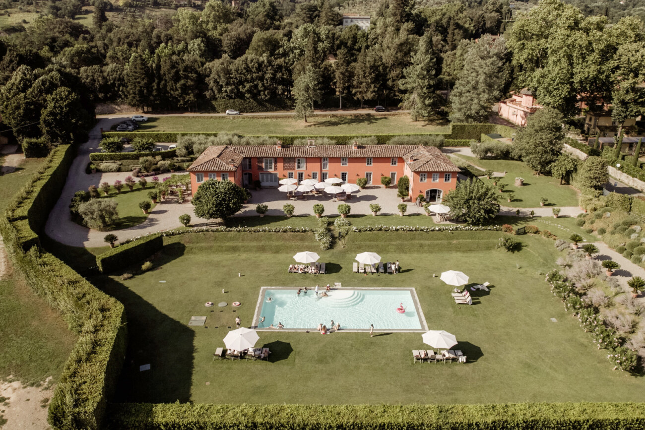 aerial view of a prewedding pool party in Villa Arancera for a destination wedding in Italy