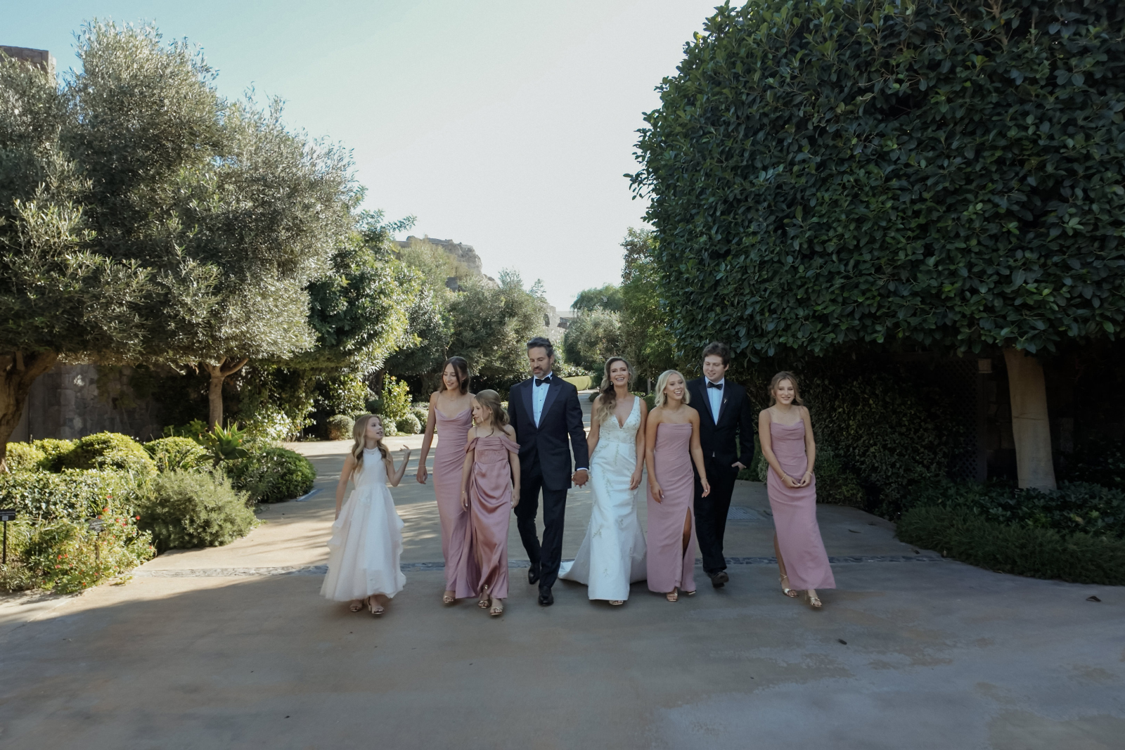 Family-centered wedding in Santorini, a bridal couple walking at Canaves Oia with their kids