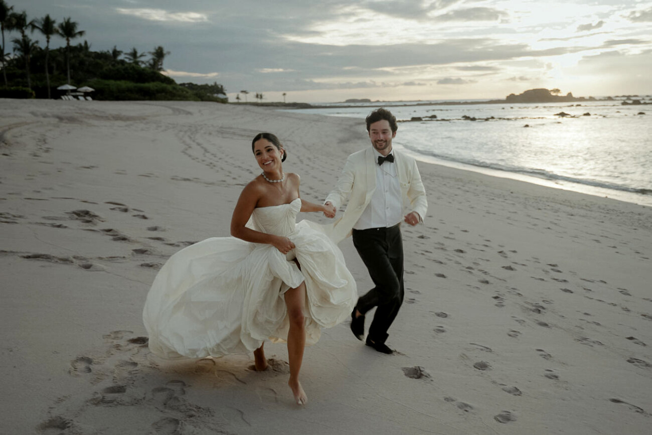Bride and groom running on the beach of the Four Seasons Punta Mita after their Luxury Indian Wedding in Mexico