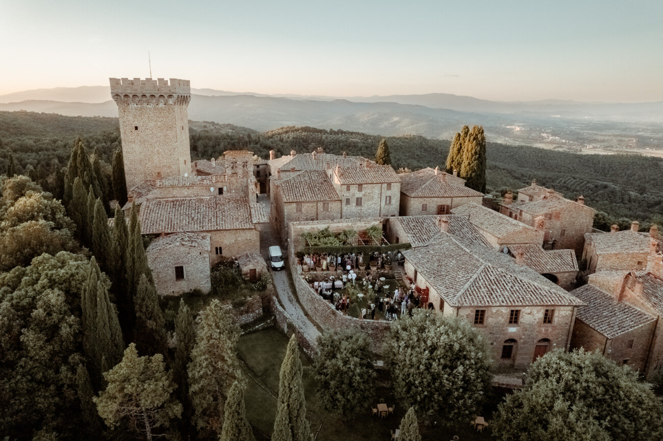 Aerial view of Castello di Gargonza while hosting a welcome wedding party at La Limonaia garden